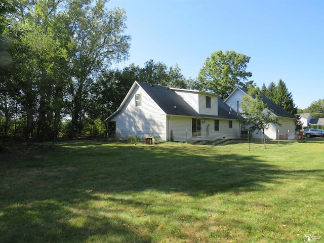 rear view of property featuring a lawn