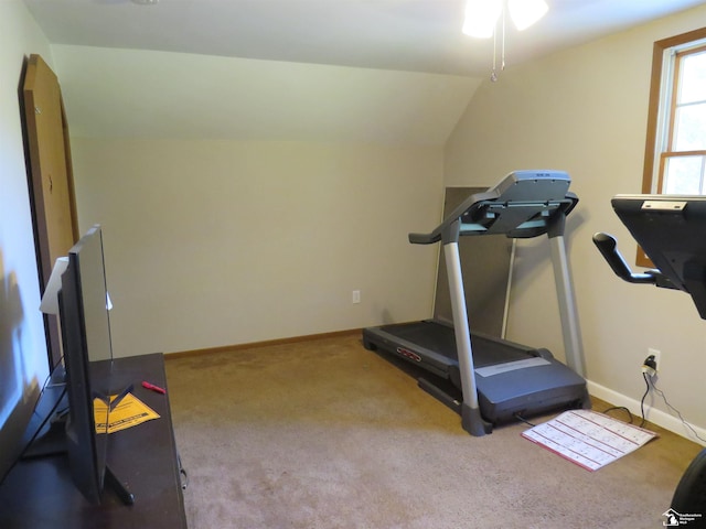 exercise room with light carpet and vaulted ceiling