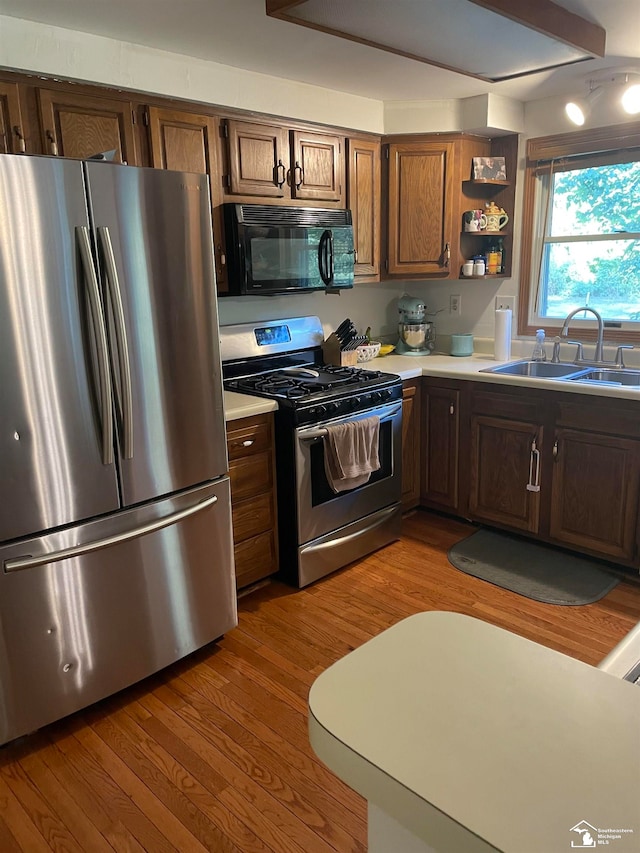 kitchen featuring light wood-type flooring, stainless steel appliances, and sink