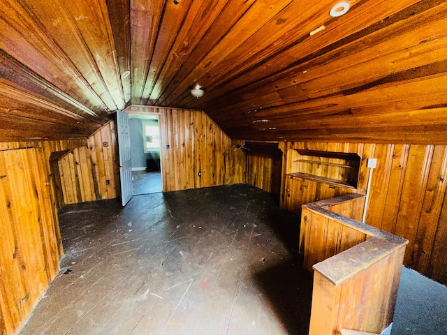 additional living space featuring lofted ceiling and wood walls