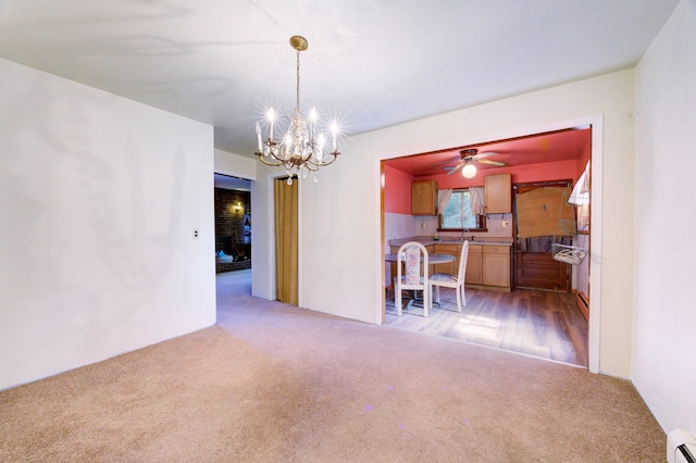 unfurnished dining area featuring hardwood / wood-style floors, ceiling fan with notable chandelier, and a baseboard radiator