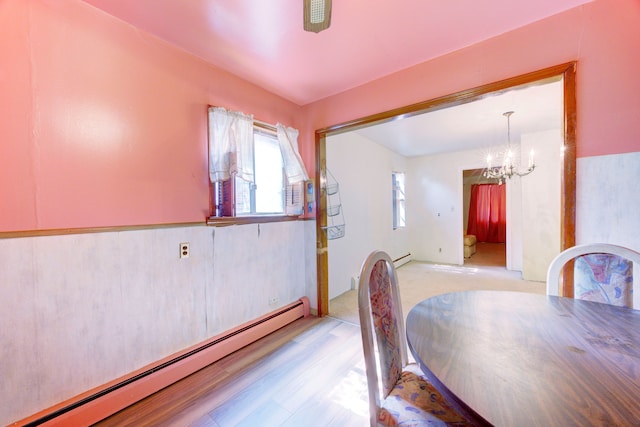 dining room with light hardwood / wood-style floors, a notable chandelier, and a baseboard heating unit