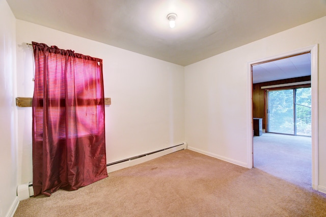 spare room featuring light carpet and baseboard heating