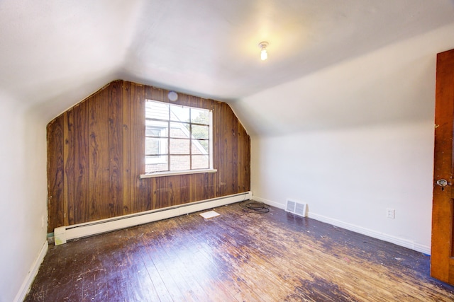 additional living space featuring a baseboard radiator, vaulted ceiling, and dark wood-type flooring