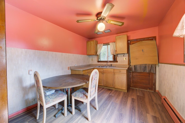 dining area with ceiling fan, sink, dark hardwood / wood-style floors, and a baseboard heating unit