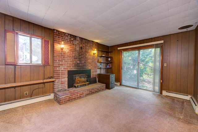 carpeted living room with wooden walls, baseboard heating, and a healthy amount of sunlight