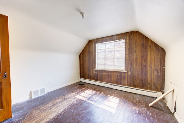 additional living space featuring vaulted ceiling, baseboard heating, and dark wood-type flooring