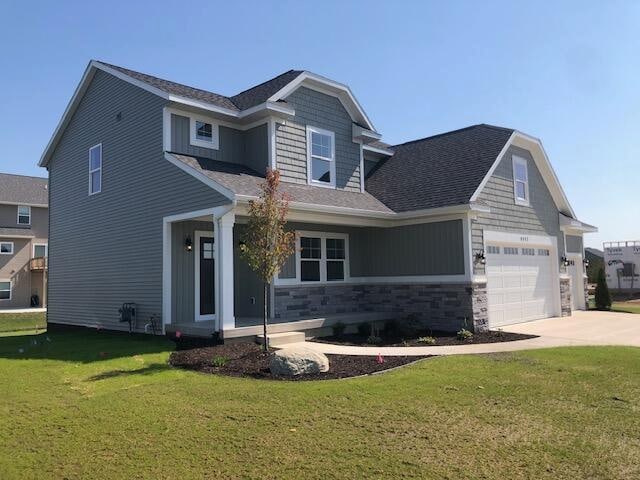 craftsman house featuring a garage and a front lawn