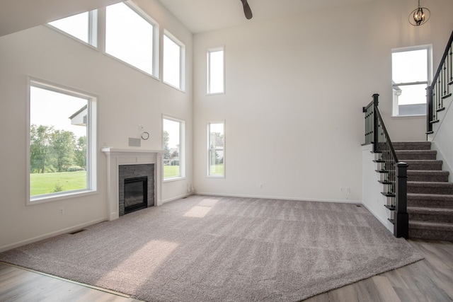 unfurnished living room featuring hardwood / wood-style floors and a high ceiling