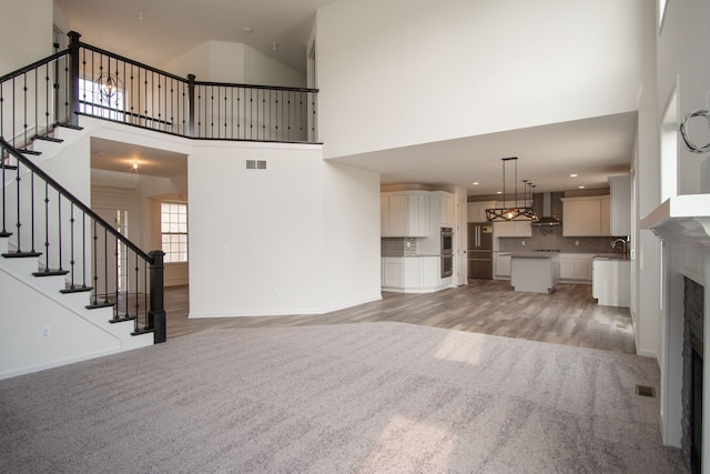 unfurnished living room with light hardwood / wood-style flooring and high vaulted ceiling