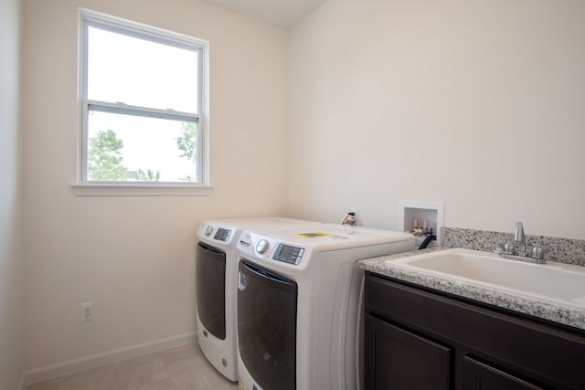 laundry room with cabinets, independent washer and dryer, a wealth of natural light, and sink