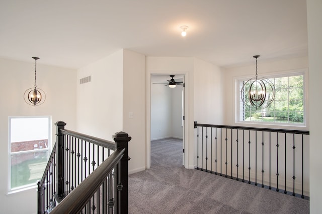 corridor featuring carpet flooring and a chandelier