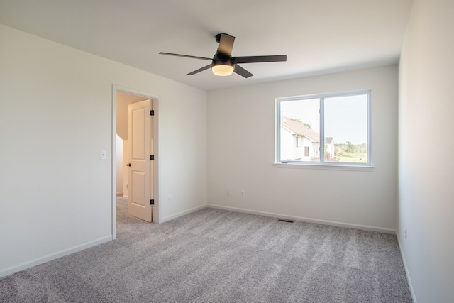 spare room featuring light colored carpet and ceiling fan