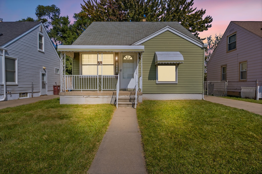 bungalow-style house with a yard and covered porch