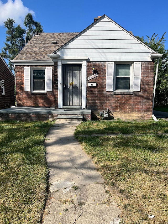 bungalow-style home with a front lawn