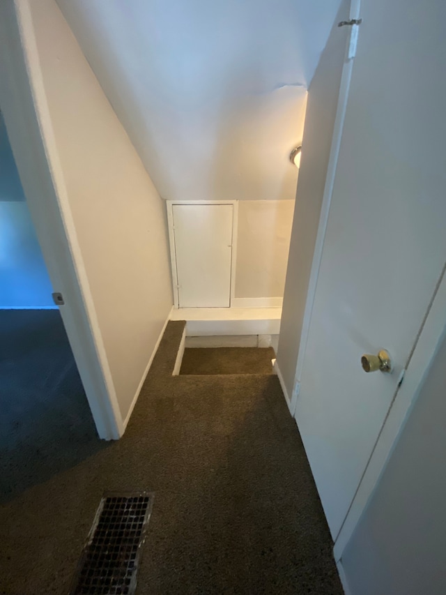 hall with carpet flooring and vaulted ceiling