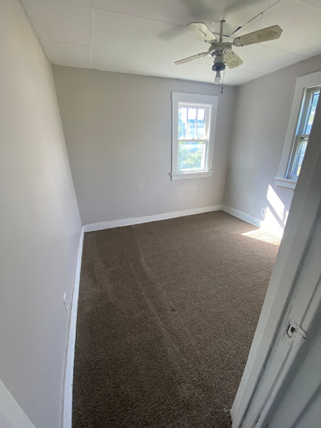 carpeted spare room featuring ceiling fan