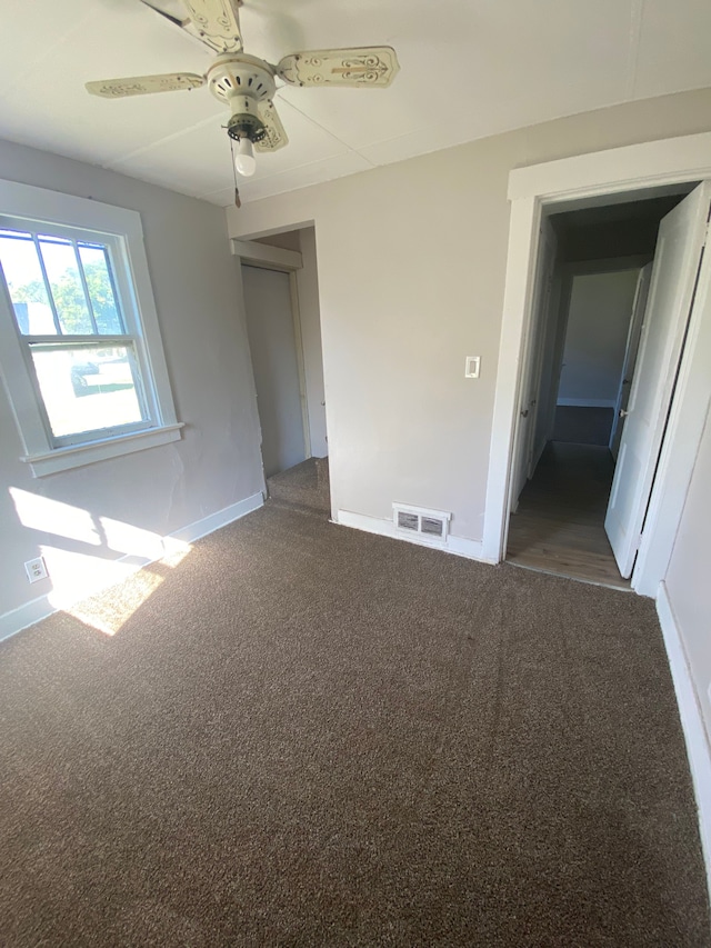 carpeted empty room featuring ceiling fan