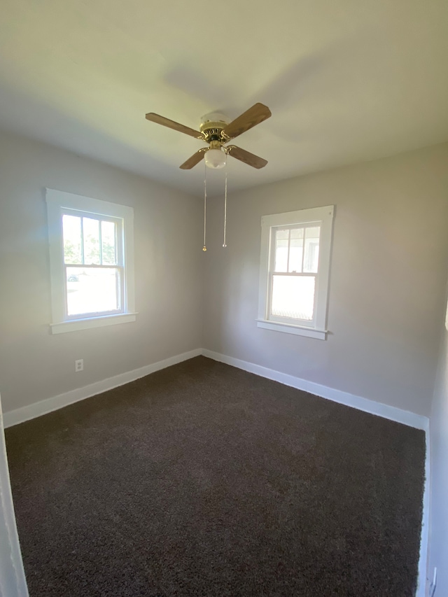 carpeted spare room featuring ceiling fan