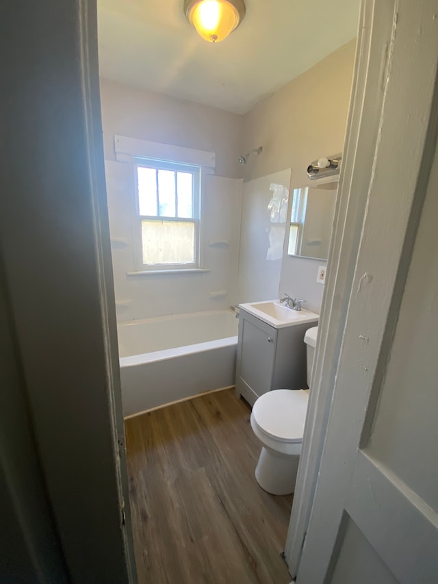 full bathroom with vanity, bathing tub / shower combination, hardwood / wood-style flooring, and toilet