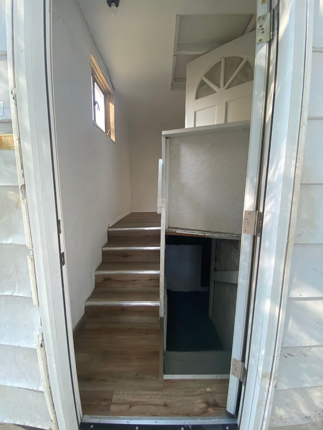 stairs featuring hardwood / wood-style floors