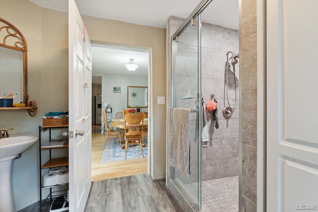 bathroom featuring hardwood / wood-style floors, a shower with door, and sink