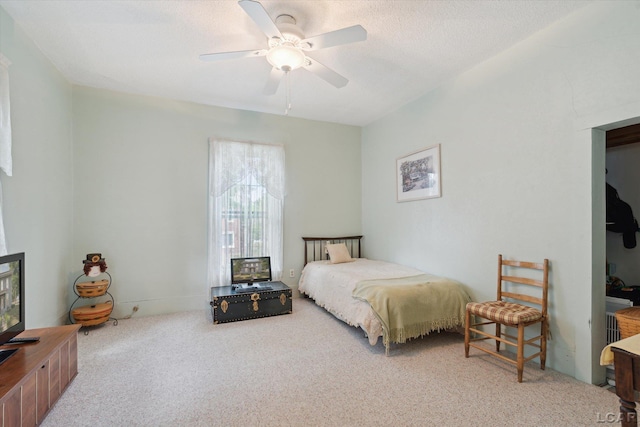 bedroom featuring ceiling fan, carpet floors, and a textured ceiling