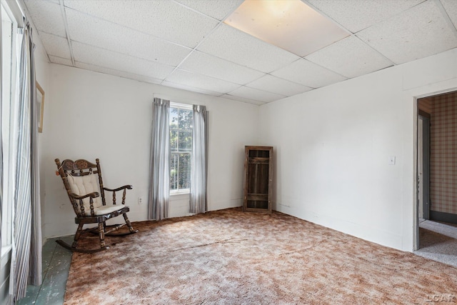 unfurnished room featuring carpet and a drop ceiling