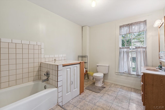 bathroom with tile patterned flooring, vanity, toilet, and a tub