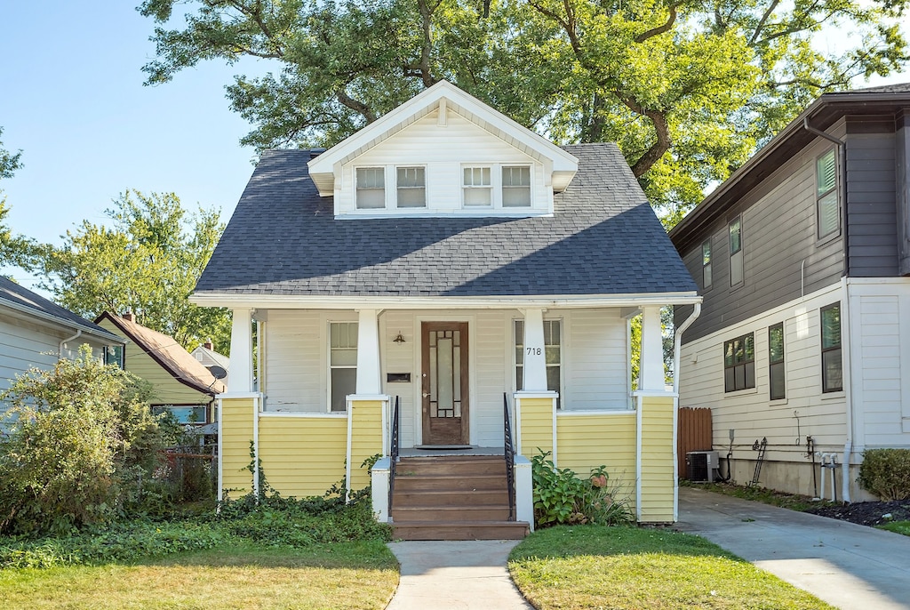 view of front of house with a front lawn and central AC unit