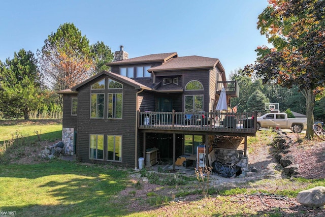 back of property with a wooden deck and a yard