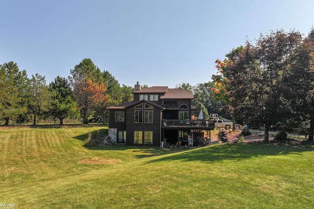 back of property with a yard and a wooden deck