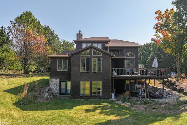 rear view of house featuring a lawn and a wooden deck