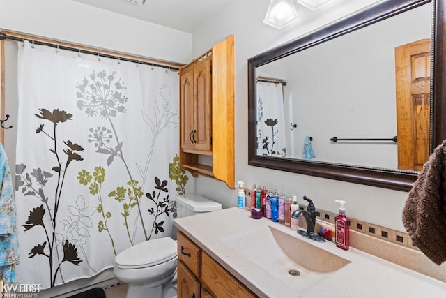 bathroom with a shower with shower curtain, vanity, and toilet