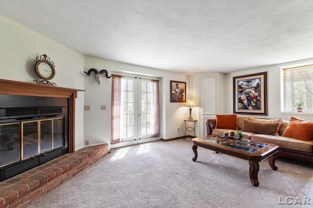 carpeted living room featuring a healthy amount of sunlight, french doors, and a brick fireplace