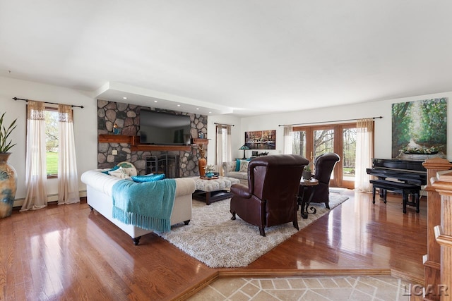 living room featuring a stone fireplace and hardwood / wood-style flooring