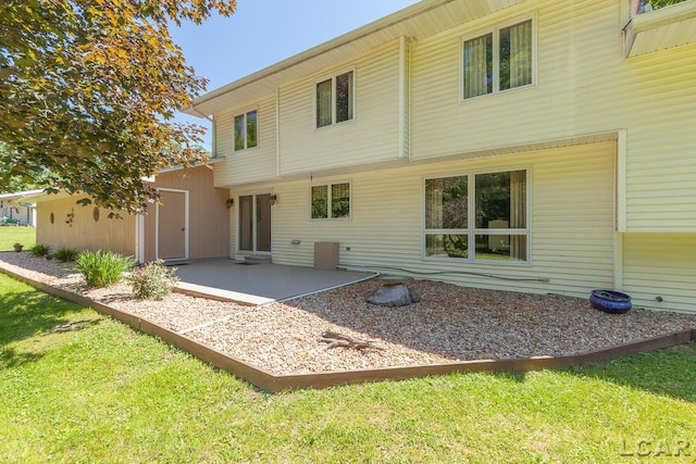 rear view of house with a yard and a patio