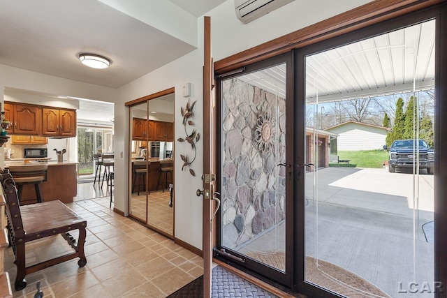 doorway to outside with french doors, light tile patterned floors, an AC wall unit, and a wealth of natural light