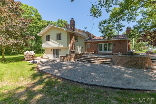 back of property with a yard and a patio