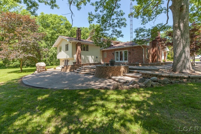 back of house featuring a yard, french doors, and a patio