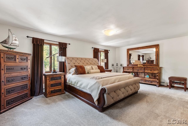 bedroom with light colored carpet and a baseboard heating unit