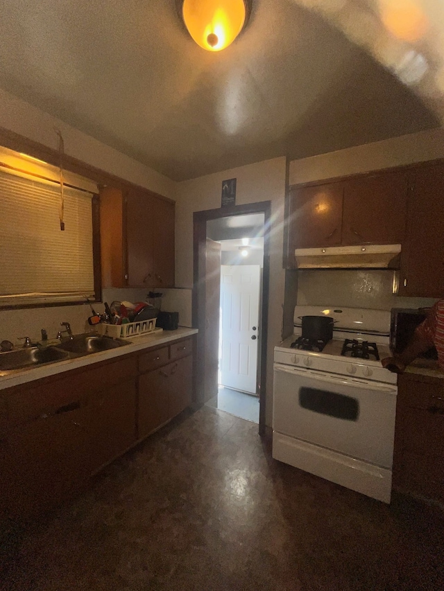 kitchen featuring a textured ceiling, white gas range, and sink