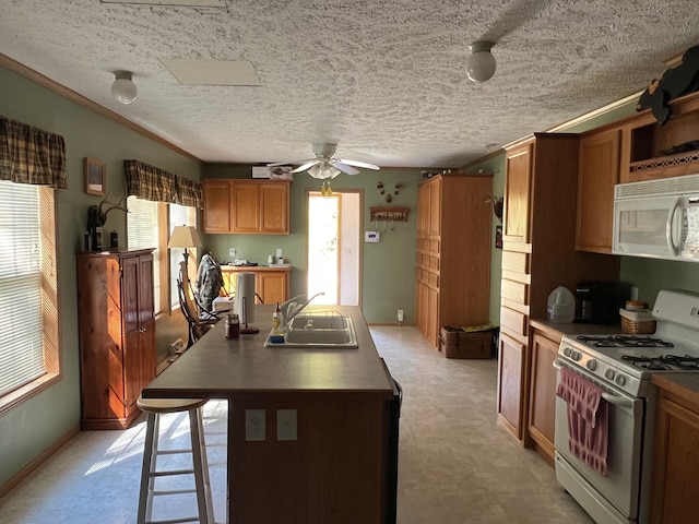 kitchen with plenty of natural light, ceiling fan, sink, and white appliances