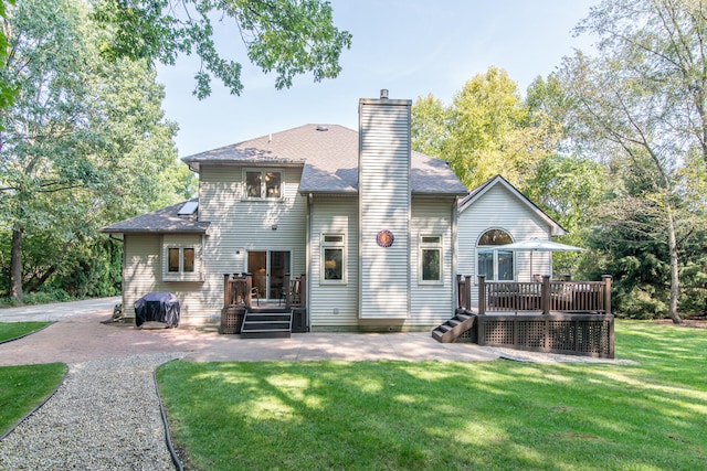 rear view of house featuring a yard and a deck