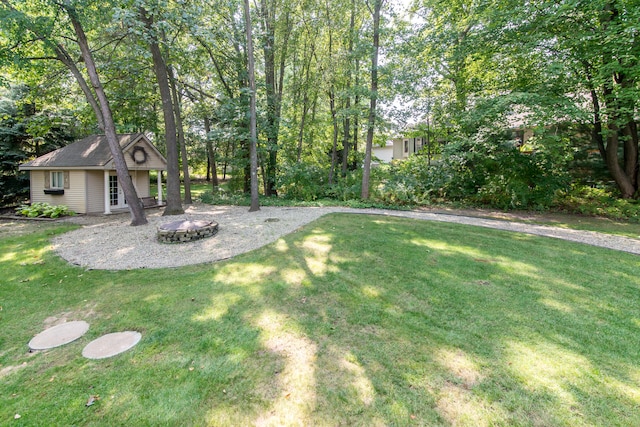 view of yard with an outdoor fire pit and an outdoor structure