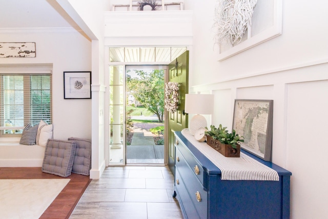 foyer entrance with hardwood / wood-style floors and crown molding