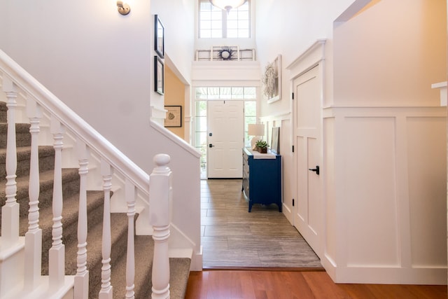 foyer featuring hardwood / wood-style floors, a healthy amount of sunlight, and a towering ceiling