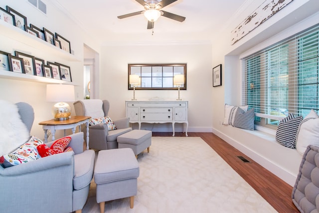 living room featuring hardwood / wood-style floors, ceiling fan, and ornamental molding