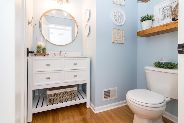 bathroom with vanity, toilet, and wood-type flooring