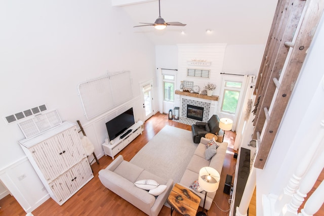 living room featuring ceiling fan, high vaulted ceiling, and hardwood / wood-style flooring